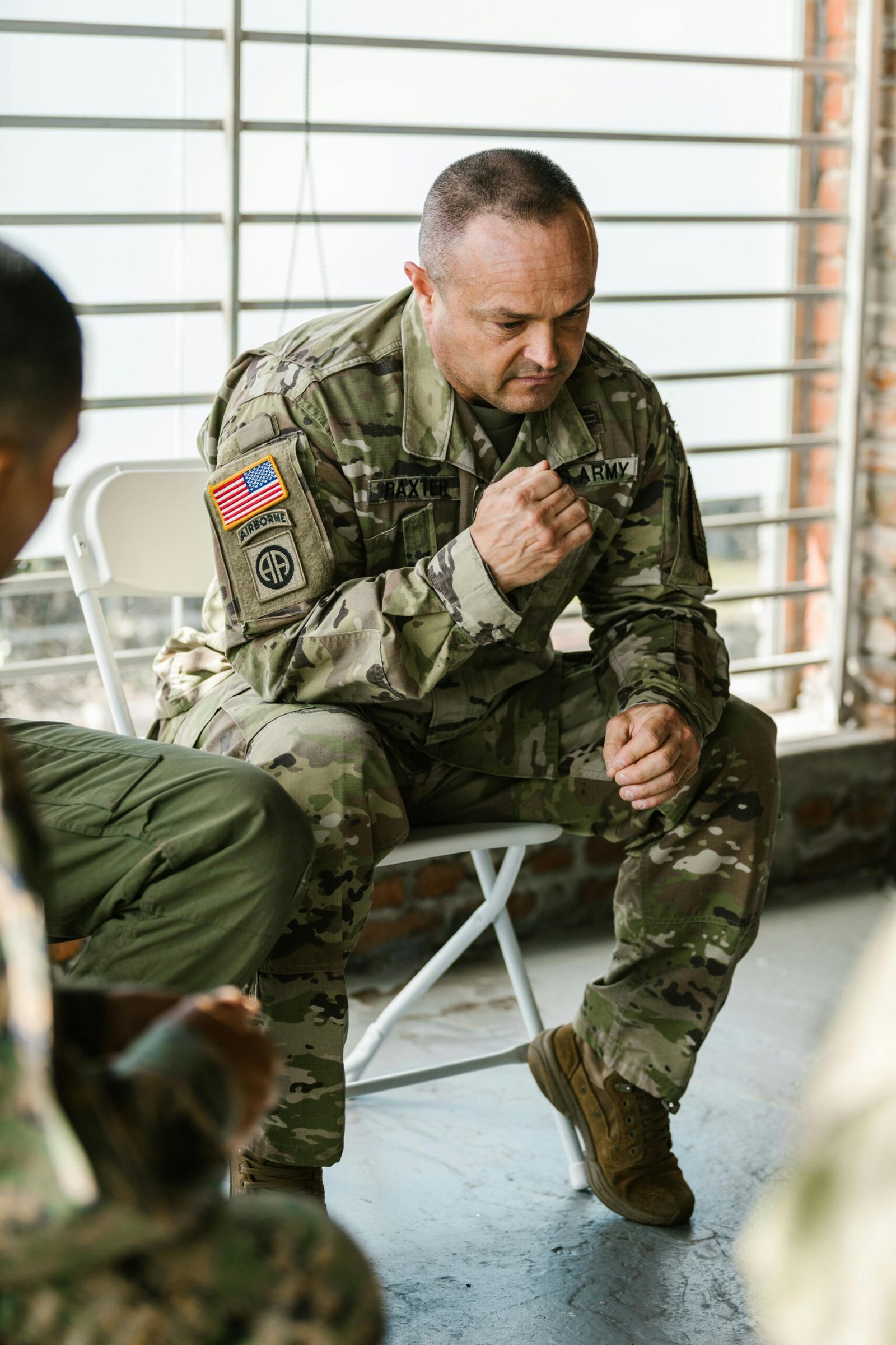 A military veteran in uniform participating in a group therapy session indoors.